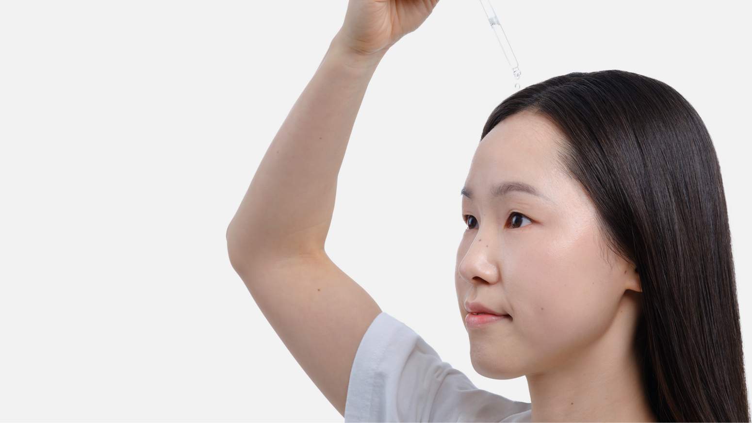 Model applying scalp serum with a dropper